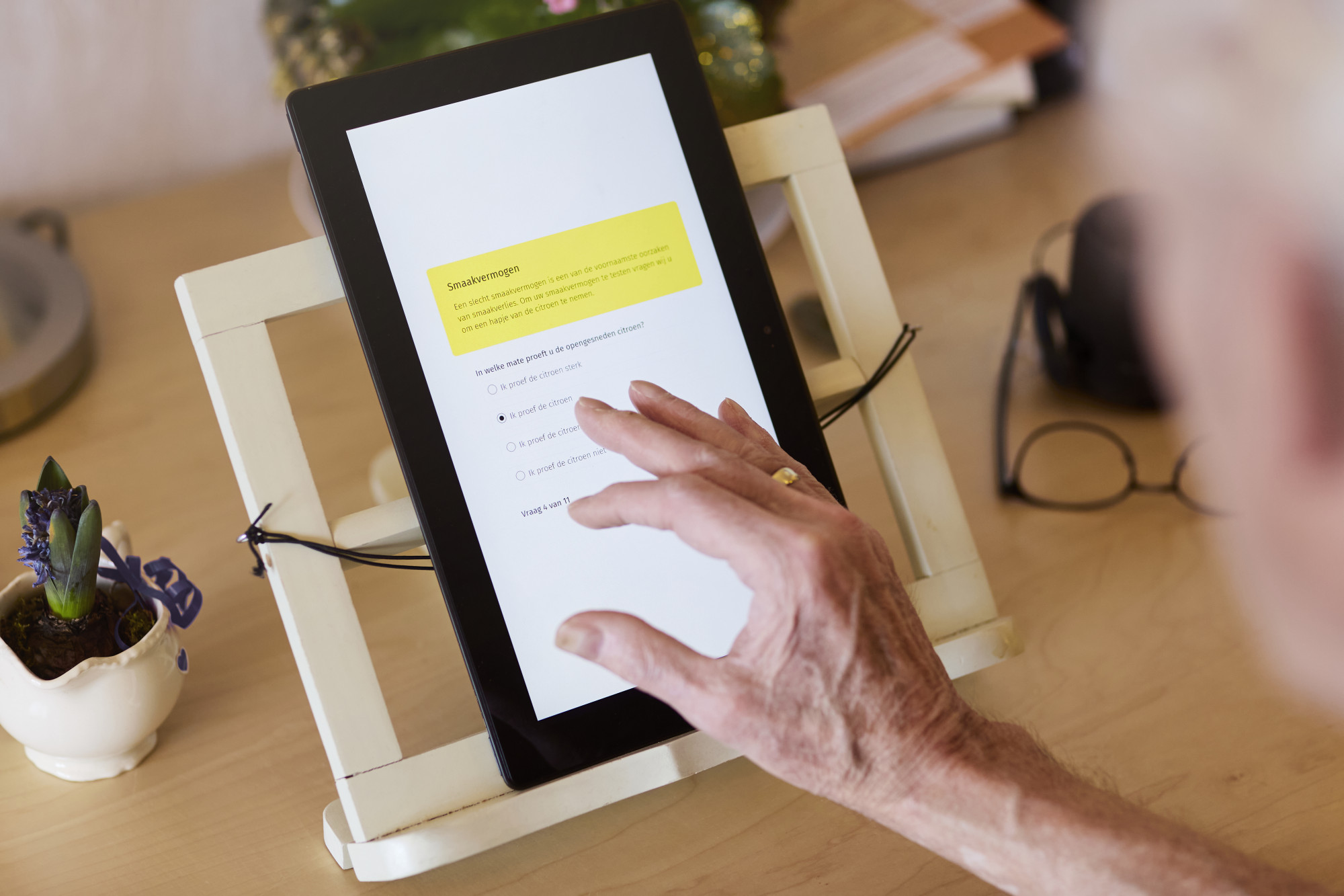Someone answering a Smaakpupil test question on a tablet at a kitchen table